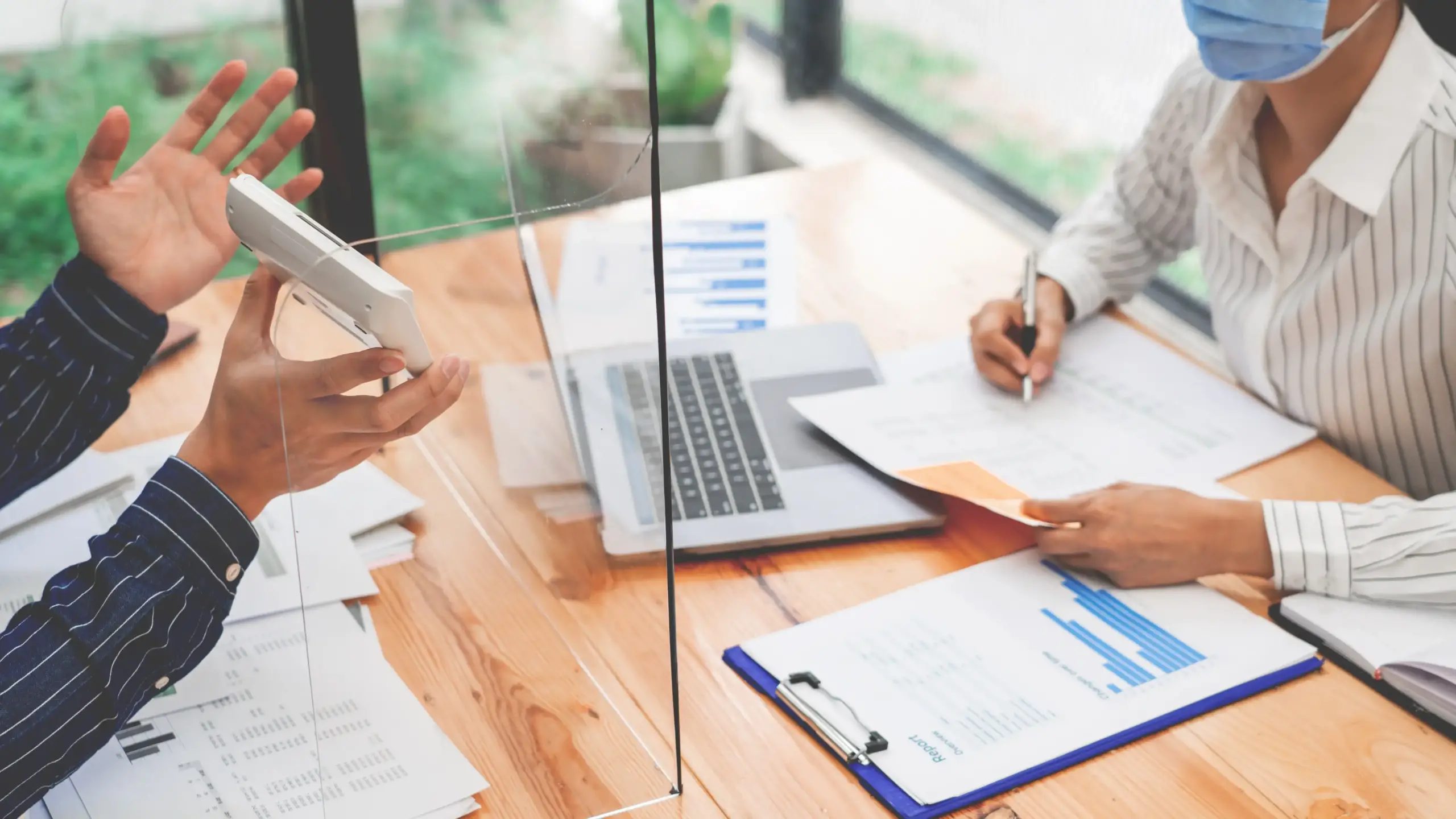 Oportunidad de Hogar en Pamplona, Norte de Santander: Mujer presentando una casa sobre una mesa, con detalles inmobiliarios como contratos y llaves. Nuestra dedicación se refleja en cada elemento, ofreciendo un servicio inmobiliario confiable y lleno de compromiso en cada paso del proceso.